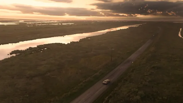 Resident Evil 7 Biohazard — a road beside wetlands at sunset