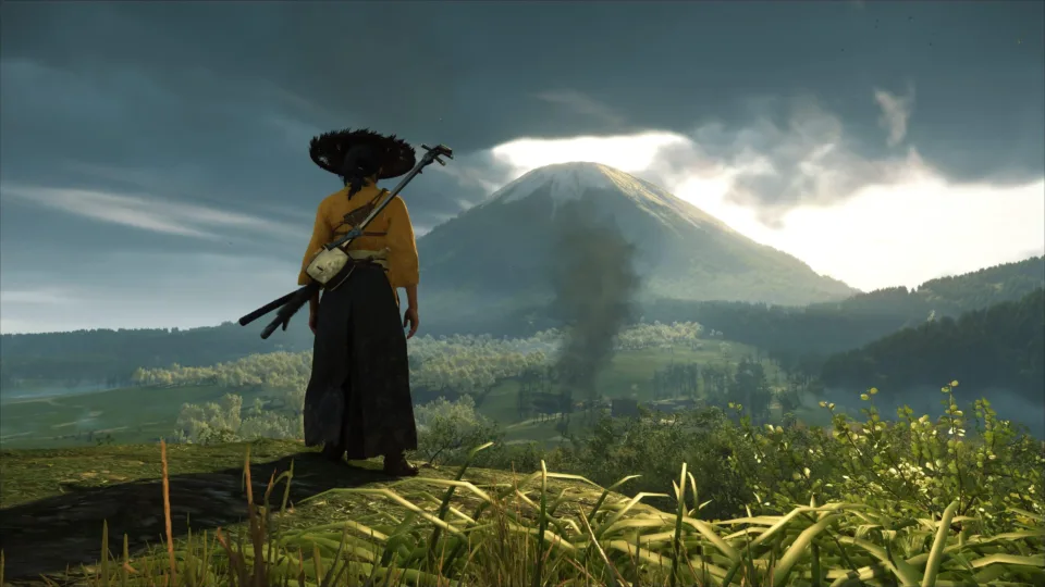 Atsu wearing traditional Japanese warrior attire against the scenic landscape of Mount Yōtei in Ghost of Yōtei.